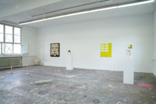 Galerie für zeitgenössische Kunst mit abstrakten Skulpturen und farbenfroher Wandkunst, ausgestellt auf weißen Wänden und Podesten in einem geräumigen, lichtdurchfluteten Raum mit abgenutztem Holzboden.