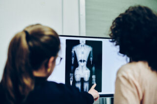 Zwei Personen vor einer Röntgenaufnahme