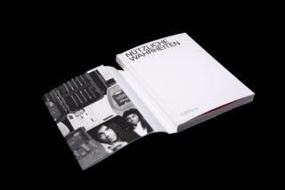 Ein aufgeschlagenes Buch auf schwarzem Untergrund zeigt links ein Schwarz-Weiß-Foto und auf einer weitgehend leeren rechten Seite den Titel „Nützliche Wahrheiten“.