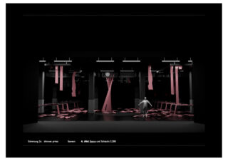 Ein Bühnenbild mit verstreuten rosa Stoffstreifen, Tischen und Stühlen und einer einzelnen menschlichen Figur, die in der Mitte unter Scheinwerfern steht.