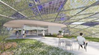 Menschen interagieren und entspannen in einem grünen Außenbereich mit Stühlen und Tischen, der von einem geometrischen, teilweise transparenten Baldachin mit Pflanzen und Solarmodulen beschattet wird.