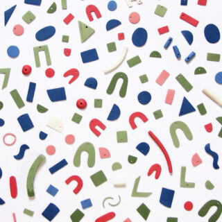 Verschiedene geometrische Formen in Rot, Grün, Blau und Weiß auf weißem Hintergrund. Zu den Formen gehören Kreise, Quadrate, Rechtecke und Kurven.