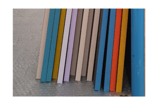 Vertikale, farbige Holzbretter werden nebeneinander auf einer Luftpolsterfolie angeordnet.