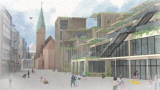 Ein moderner Stadtplatz mit Menschen, die spazieren gehen, Rad fahren und sitzen; zeitgenössische grüne Gebäude und eine historische Kirche mit einem hohen Turm im Hintergrund.