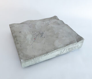 Ein quadratisches, dreidimensionales topografisches Modell mit einer rauen Oberflächenstruktur, das Geländedetails und eine numerische Skala „1/10000“ an der Seite zeigt.