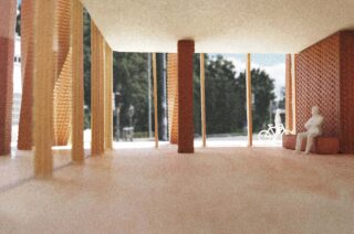 Innenansicht eines Architekturmodells mit Holzbalken, Ziegelwänden, großen Fenstern und zwei sitzenden weißen Figuren; draußen ist durch das Glas ein Fahrrad sichtbar.