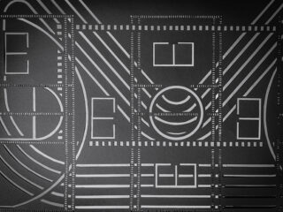 Geometrisches Muster mit parallelen Linien, Rechtecken, Quadraten, Kreisen und gestrichelten Rändern auf dunklem Hintergrund.