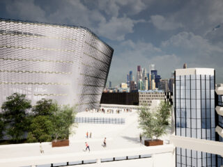 Im Vordergrund sind moderne Gebäude mit geometrischen Fassaden und begrünten Dächern zu sehen, im Hintergrund ist unter einem bewölkten Himmel die Skyline einer Stadt zu sehen.