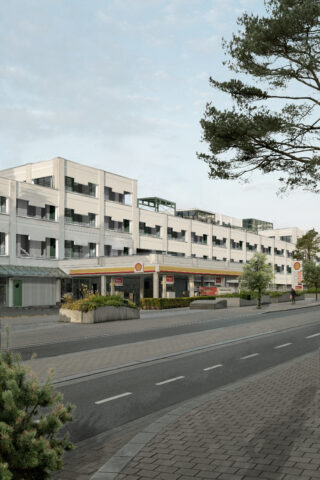 Ein modernes, mehrstöckiges weißes Gebäude mit Geschäften im Erdgeschoss liegt an einer ruhigen, von Bäumen und Grün gesäumten Straße unter klarem Himmel.