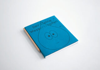 Ein blaues Buch mit dem Titel „Der kleine Wassertropfen“ mit einem einfachen Cartoon-Wassertropfengesicht auf dem Cover, neben einem Bleistift auf weißem Hintergrund.