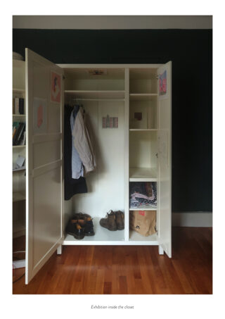 Ein offener weißer Kleiderschrank mit Hemden, Jacken, Schuhen und einer Papiertüte darin; Regale und Kleiderbügel sind sichtbar, an den Türen und Wänden sind kleine Bilder aufgeklebt.