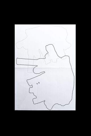 Ein weißes Blatt Papier mit zwei unregelmäßigen, abstrakten schwarzen Umrissen übereinander, die vor einem schwarzen Hintergrund angezeigt werden.