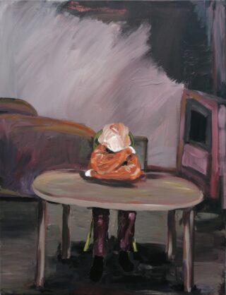 Eine Person mit verdecktem Gesicht sitzt allein an einem Tisch in einem schwach beleuchteten Raum mit einer offenen Tür und einem Sofa im Hintergrund.