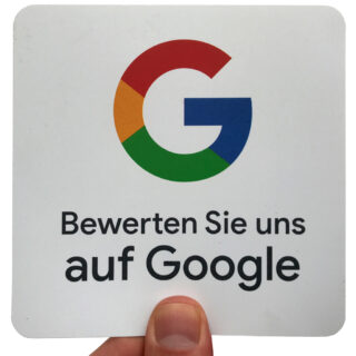 Eine Hand hält ein Schild mit dem Google-Logo und dem deutschen Text „Bewerten Sie uns auf Google“.