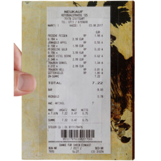 Eine Hand hält einen Kassenbon von NEUKAUF, auf dem verschiedene Früchte und deren Preise aufgelistet sind, insgesamt beträgt der Betrag 7,22 Euro.