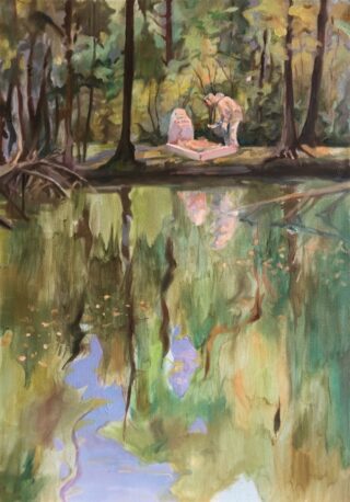 Eine Person steht neben einer Steinskulptur in einem Waldgebiet, im Vordergrund spiegeln sich Bäume und Grün in einem ruhigen Teich.