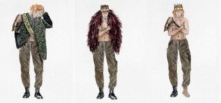 Drei Männer stehen nebeneinander, jeder trägt weite braune Hosen und einen einzigartigen Hut mit unterschiedlichen Accessoires wie einer grünen Schärpe, einem Pelzumhang und einem Armschutz; alle sind barfuß oder tragen nur einen Schuh.