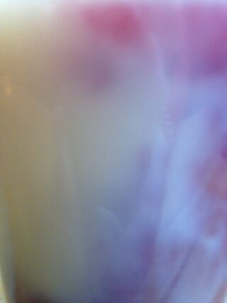 Verschwommenes Bild mit einem Farbverlauf aus sanften Lila-, Rosa- und Weißtönen, die ineinander übergehen, ohne dass deutliche Formen oder Objekte sichtbar sind.