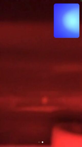Ein verschwommenes, rot getöntes Bild mit einer hellblauen und weißen rechteckigen Überlagerung in der oberen rechten Ecke.