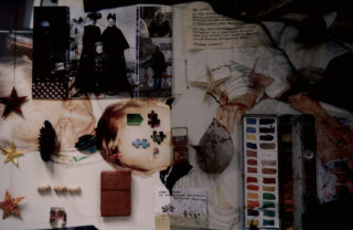 Eine Collage mit alten Fotografien, Origami-Sternen, Blättern, Aquarell-Set, kleinen Objekten und handschriftlichen Notizen, angeordnet auf einem Tisch.