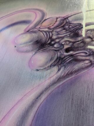 Nahaufnahme eines abstrakten Kunstwerks mit glatten, organischen Formen und Gestalten in Rosa-, Lila- und Grautönen mit einer glänzenden, reflektierenden Oberfläche.