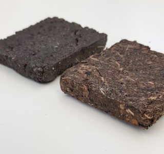 Zwei rechteckige Erdblöcke, einer dunkel und glatt, der andere braun und faserig, nebeneinander auf einer weißen Oberfläche platziert.