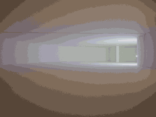 Ein minimalistischer, leerer Raum mit weißen Wänden, einer gewölbten Decke und sanftem Licht, das aus einer entfernten Öffnung auf der rechten Seite kommt.