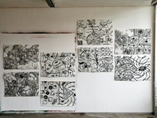 Neun abstrakte Schwarz-Weiß-Zeichnungen mit geometrischen und organischen Formen werden in einer gitterartigen Anordnung auf einer weißen Wand angezeigt.