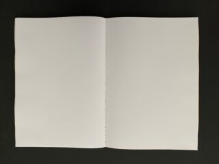 Vor einem dunklen Hintergrund wird ein offenes, leeres Notizbuch mit weißen Seiten angezeigt.