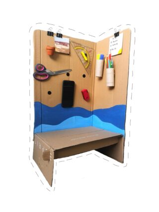 Eine selbstgebaute Lernkabine aus Pappe, mit blauer Farbe bemalt, mit Schreibwaren, Schere, Telefon und Notizen mit Klammern und daran befestigten Behältern.