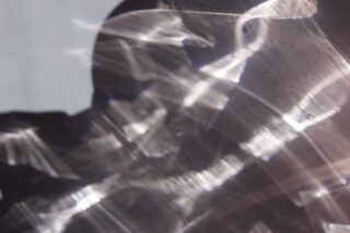 Abstrakte Licht- und Schattenmuster werden auf eine Oberfläche geworfen und erzeugen überlappende Formen und Texturen.