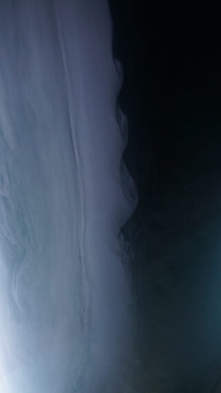 Ein Farbverlauf von Hellgrau, das in Dunkelgrau oder Schwarz übergeht, mit glatten, wolkigen und welligen Texturen, die an Rauch oder Flüssigkeit erinnern.