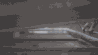 Eine Nahaufnahme des Inneren einer Metalldruckmaschine, die bewegliche mechanische Teile und Zahnräder in Bewegung zeigt.