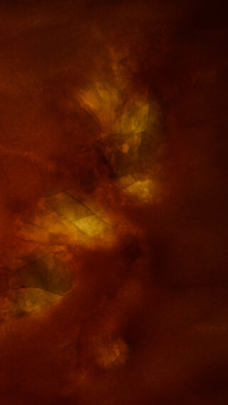 Abstraktes Bild in dunklen Rotbraun- und Gelbtönen mit verschwommenen, strukturierten Flecken und aquarellartigem Aussehen.