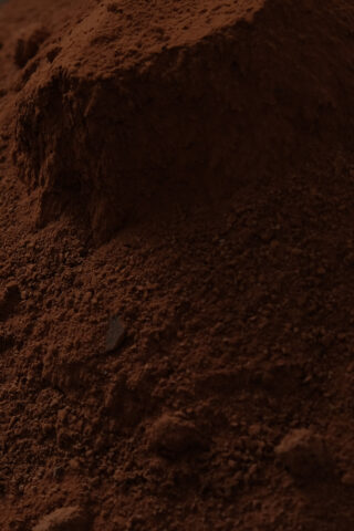 Eine Nahaufnahme eines Hügels Kakaopulver, die seine feine, braune und leicht klumpige Textur zeigt.