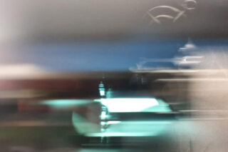 Abstraktes Bild mit unscharfen horizontalen Licht- und Farbbändern, darunter Blaugrün, Blau und Grau, mit undeutlichen Formen und sanften Farbverläufen im Hintergrund.