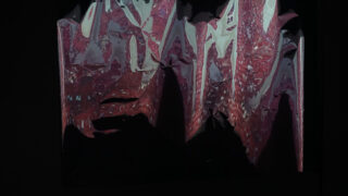 Abstraktes Bild mit gezackten, reflektierenden Oberflächen in roten, weißen und violetten Farbtönen, die an verzerrtes Glas oder Metall erinnern, vor einem dunklen Hintergrund.