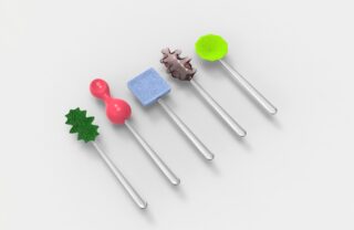 Fünf silberne Stäbchen, jeder mit einer einzigartigen, farbenfrohen strukturierten Form versehen: grünes Blatt, rosa Kugeln, blauer Würfel, braune Zahnräder und grünes Sechseck, angeordnet auf einem weißen Hintergrund.