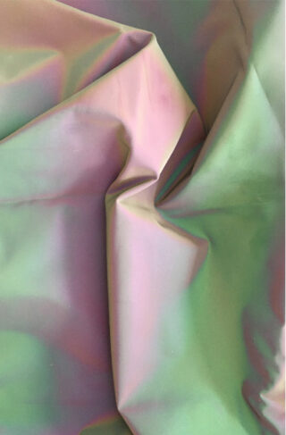 Nahaufnahme eines schillernden Stoffes mit Falten und Knicken, der einen Farbverlauf in Pastelltönen, darunter Rosa, Grün und Lila, aufweist.