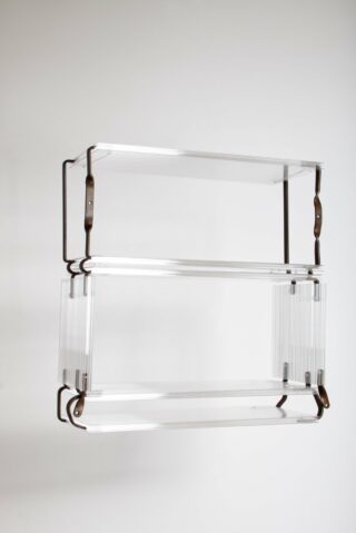 Dreistufiges Wandregal aus durchsichtigem Acryl mit schwarzen Metallhalterungen vor schlichtem weißen Hintergrund.