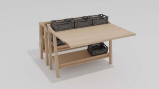 Ein Holztisch mit verlängerter Platte, darunter einem Regal und vier schwarzen Aufbewahrungsbehältern aus Kunststoff auf der Oberfläche und dem Regal.