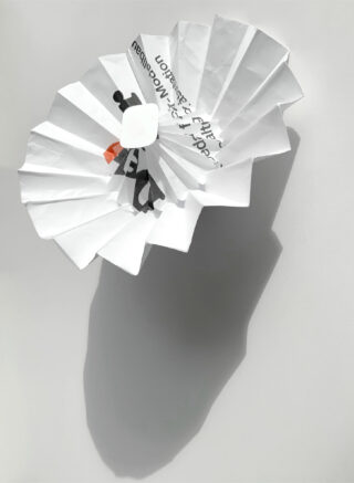Ein zerknüllter Kaffeefilter aus Papier mit teilweise aufgedrucktem Text wirft einen deutlichen Schatten auf eine schlichte weiße Oberfläche.