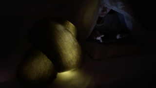 Eine Person unter einer Decke benutzt im Dunkeln ein Tablet, während in der Nähe zwei beleuchtete Kissen liegen.