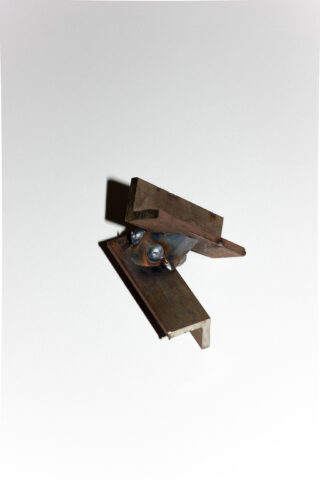 Auf einem schlichten weißen Hintergrund wird ein kleines Metallobjekt angezeigt, das aus verschweißten rechteckigen und L-förmigen Stahlteilen besteht.