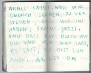 Eine handschriftliche Notiz in deutscher Sprache auf leerem Papier. Blaugrüner Text füllt den Großteil der Seite. Auf der Rückseite ist etwas schwacher Text sichtbar.
