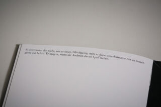 Eine Nahaufnahme einer Buchseite mit deutschem Text oben auf einem schlichten weißen Hintergrund.