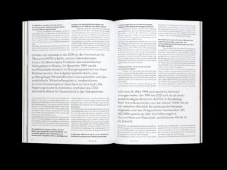 Offenes Buch mit zwei Seiten deutschem Text in schwarzer Schrift mit Überschriften und Absätzen vor schwarzem Hintergrund. Die Seiten enthalten keine Bilder oder Illustrationen.