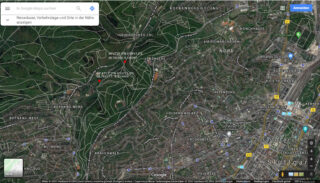 Satellitenansicht von Stuttgart, Deutschland, mit Stadtgebieten, Parks und bewaldeten Hügeln; Kartenbeschriftungen zeigen Stadtteile und Sehenswürdigkeiten an.