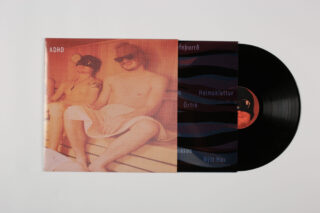 Eine teilweise aus ihrer Hülle gezogene Vinyl-Schallplatte mit einem Foto von zwei Personen in Badeanzügen und Sonnenbrillen, die in einer Sauna sitzen.