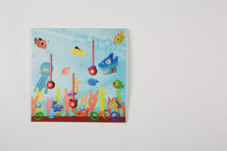 Ein farbenfrohes Spielbrett mit Unterwassermotiven, Fischillustrationen, vier vertikalen roten Schiebereglern und sechs grün umkreisten Bereichen am unteren Rand.